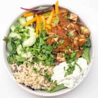 chicken shawarma bowls filled with rice, tzatziki, greens, and fresh veggies